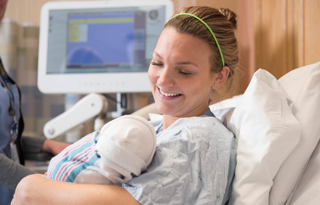 Mother smiling at newborn baby