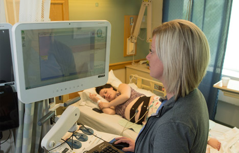 Pregnant patient laying in bed getting a non stress test